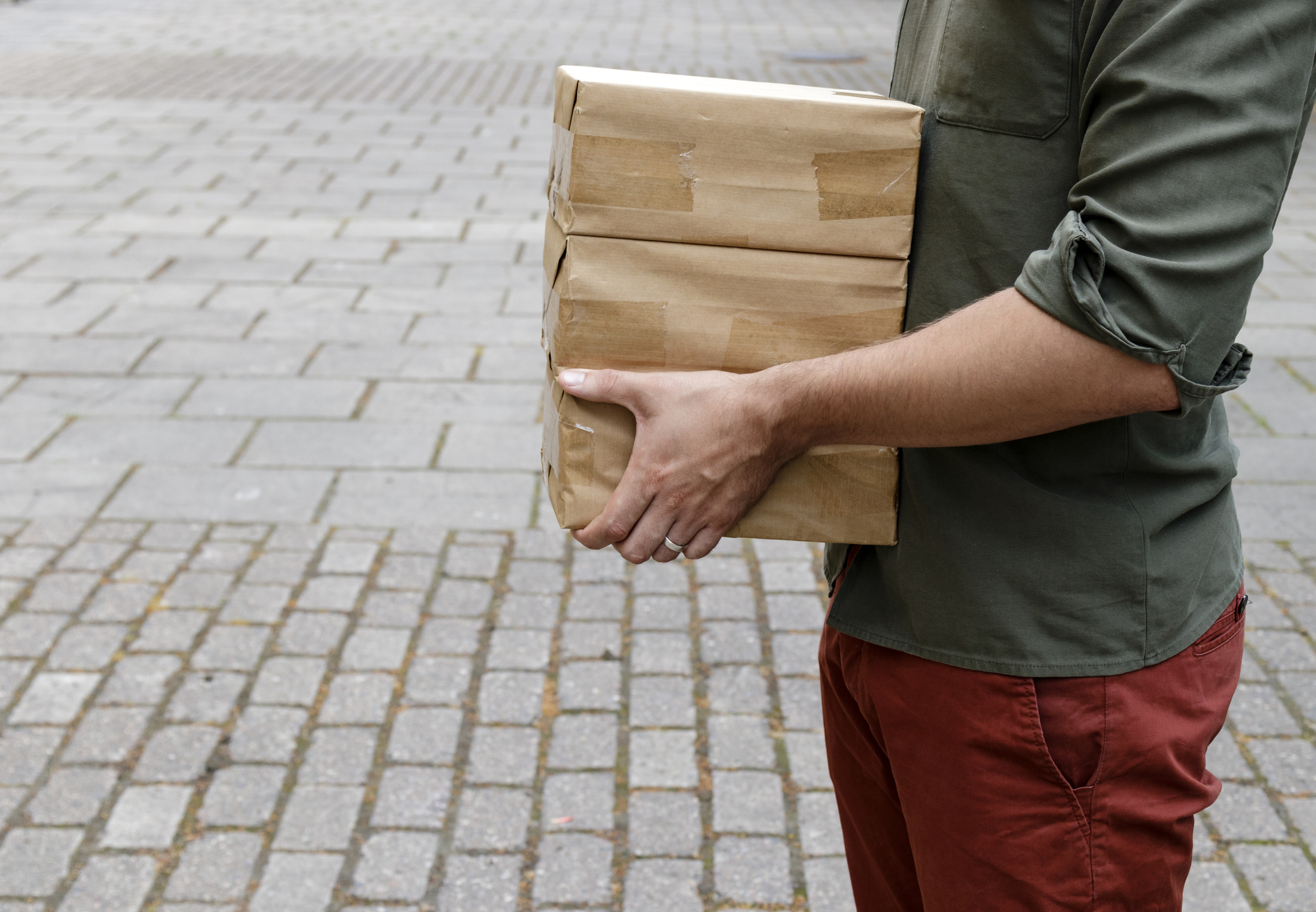 Package delivery. Delivery man is holding packaging or cardboard boxes. Delivery man at work.